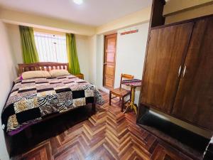 1 dormitorio con 1 cama y suelo de madera en Euro Hostal, en Cusco
