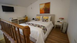 a small bedroom with a bed and a staircase at Adamas House Hotel Boutique in Quito