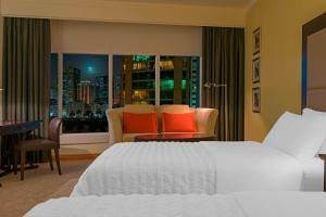 a bedroom with a bed and a view of a city at Le Royal Meridien Abu Dhabi in Abu Dhabi