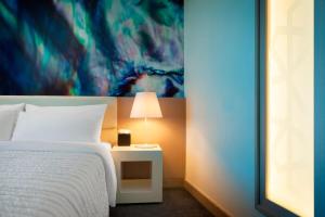 a bedroom with a bed and a table with a lamp at Le Royal Meridien Abu Dhabi in Abu Dhabi