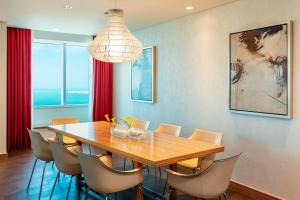 a dining room with a wooden table and chairs at Le Royal Meridien Abu Dhabi in Abu Dhabi