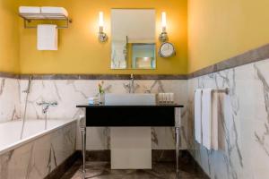 a bathroom with a sink and a tub and a mirror at Le Royal Meridien Abu Dhabi in Abu Dhabi