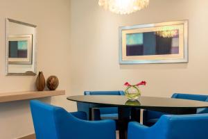 a dining room with a table and blue chairs at Le Royal Meridien Abu Dhabi in Abu Dhabi