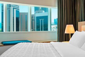 a hotel room with a bed and a large window at Le Royal Meridien Abu Dhabi in Abu Dhabi