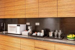 a kitchen counter with a microwave and a coffee maker at Le Royal Meridien Abu Dhabi in Abu Dhabi