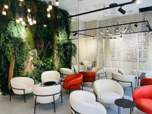 a waiting room with red and white chairs and plants at Hotel Central Basilica in Budapest