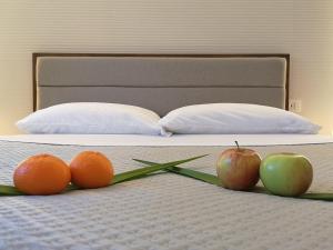 two oranges and two apples on a bed at Panorama Suite in Piazza Armerina