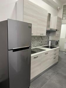 a kitchen with a stainless steel refrigerator and cabinets at CasaCalzolari FIERA METEO TECNOPOLO BO in Bologna