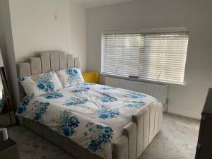 um quarto com uma cama grande com flores azuis em Warm welcoming Home em Manchester