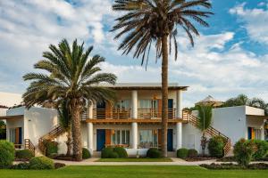 une maison avec des palmiers devant elle dans l'établissement Hotel Paracas, a Luxury Collection Resort, Paracas, à Paracas