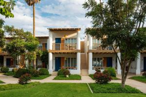 an exterior view of a building with palm trees at Hotel Paracas, a Luxury Collection Resort, Paracas in Paracas