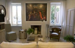 a living room with a fireplace and a painting on the wall at Le Stanze del Cardinale in Pavia