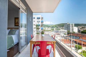 里約熱內盧的住宿－Jacarepaguá Residence - Quarto em apartamento，带阳台的带桌椅的房间
