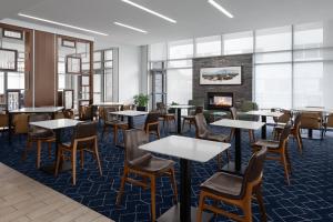 a restaurant with tables and chairs and a fireplace at Courtyard Cleveland University Circle in Cleveland