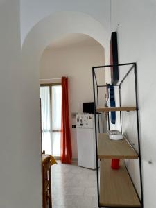 a room with a kitchen with a shelf and a refrigerator at La Perla di Lampedusa in Lampedusa