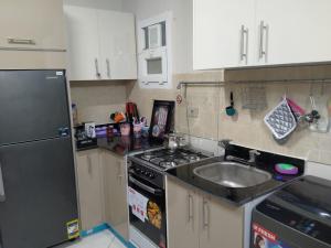 uma cozinha com um lavatório e um fogão forno superior em 2 Bedroom Apartment with pool view em Sharm el Sheikh