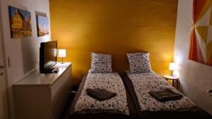 two beds in a small room with a tv at Sydfynsk idyl tæt på det hele. in Svendborg
