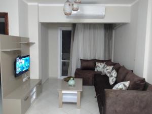 2 Bedroom Apartment with pool view في شرم الشيخ: غرفة معيشة مع أريكة وتلفزيون