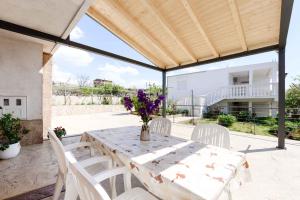 un patio con mesa y sillas blancas en Apartment in Razanac - Zadar Riviera 41400, en Ražanac