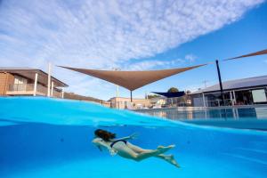 a woman swimming in the water in a pool at BIG4 River Myall Holiday Resort in Bulahdelah
