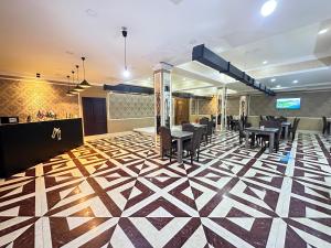 un vestíbulo con mesas y sillas en un piso geométrico en Istanbul Gold Hotel, en Baku