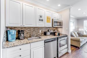 a kitchen with white cabinets and a sink at Sunset Harbor Palms 2-304 in Navarre