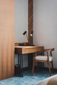 a wooden desk with a lamp and a chair at Bristol Hotel Podgorica in Podgorica