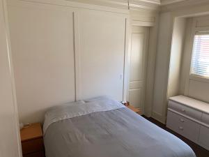 una camera da letto bianca con un letto e una finestra di Private cozy suite near Dyke and Fisherman's Wharf a Richmond
