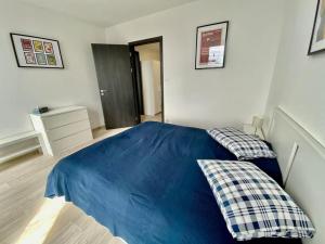 a bedroom with a blue bed with two pillows at Two-room apartment with garage in the center in Pilsen