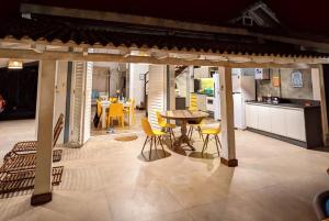 uma cozinha e sala de jantar com mesa e cadeiras em Linda Casa Praia de Pauba em condominio em São Sebastião