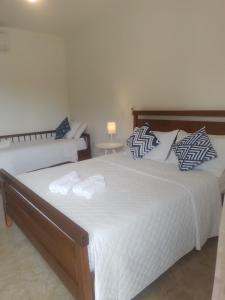 1 dormitorio con 2 camas con sábanas y almohadas blancas en Pousada Cheiro da Terra, en Capitólio