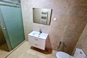 La salle de bains est pourvue d'un lavabo, d'un miroir et de toilettes. dans l'établissement F4 vue sur mer, à Oran