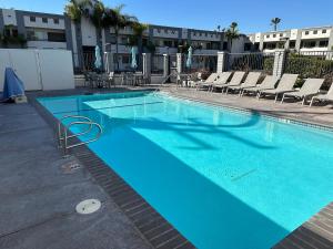una gran piscina azul con sillas y mesas. en Solara Inn and Suites, en Anaheim