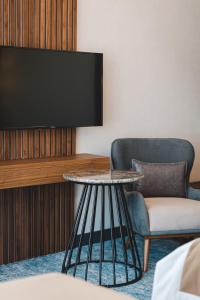 a room with a tv and two chairs and a table at Bristol Hotel Podgorica in Podgorica