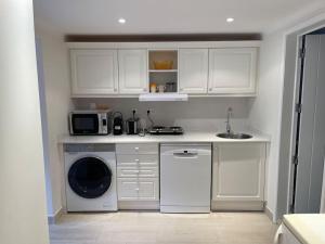 a kitchen with a washing machine and a microwave at Studio with Private Swimming Pool and Garden in Cascais