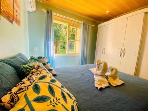 Zwei Babys sitzen auf einem Bett in einem Zimmer in der Unterkunft Casa ampla e aconchegante em Gramado in Gramado