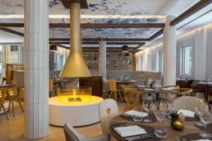 un ristorante con tavoli e sedie e un soffitto con fiori blu di Caro & Selig, Tegernsee, Autograph Collection a Tegernsee