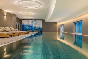 an indoor swimming pool with a swimming meditation room with two beds at Caro & Selig, Tegernsee, Autograph Collection in Tegernsee