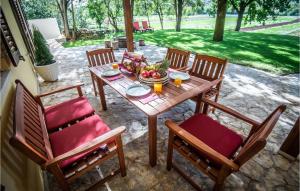 a wooden table with chairs and a bowl of fruit on it at Stunning Home In Dicmo With Kitchen in Dicmo