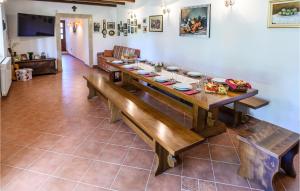 a dining room with a long wooden table and benches at Stunning Home In Dicmo With Kitchen in Dicmo
