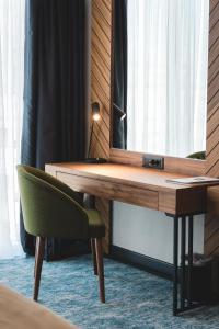 a desk with a mirror and a chair in a room at Bristol Hotel Podgorica in Podgorica