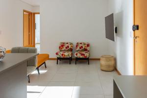 2 sillas sentadas en una habitación con azulejos blancos en Clube Frente Mar | Sauna | Piscina | Beto Carrero, en Piçarras