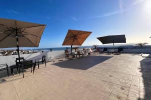 a patio with tables and chairs and umbrellas at Luxury 2BR Condo Rosarito (D) in Rosarito