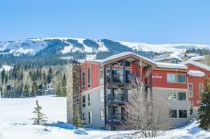 a hotel in the snow with mountains in the background at Snowmass Village, 3 Bedroom at the Enclave - Ski-in Ski-out with Airport Transfers in Snowmass Village