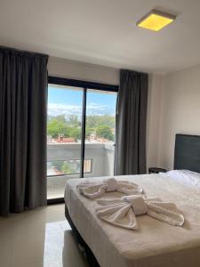 a bedroom with a large bed and a large window at Apart Hotel Jorge I in Santiago del Estero
