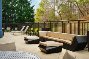 a patio with a couch and tables and chairs at SpringHill Suites Edgewood Aberdeen in Bel Air