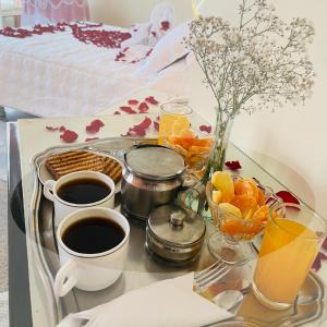 - un plateau avec des tasses de café et des fruits sur une table dans l'établissement Hotel Kokusai, à Cochabamba