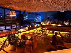 eine Dachterrasse mit Tischen, Stühlen und Lichtern in der Unterkunft Casa Sabina Down Town Mexico City in Mexiko-Stadt