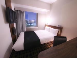 東京にあるアパホテル〈日本橋浜町駅南〉のベッドと窓が備わるホテルルーム