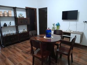 a dining room with a table and chairs and a television at Hospedagem Tia Marli in Pomerode